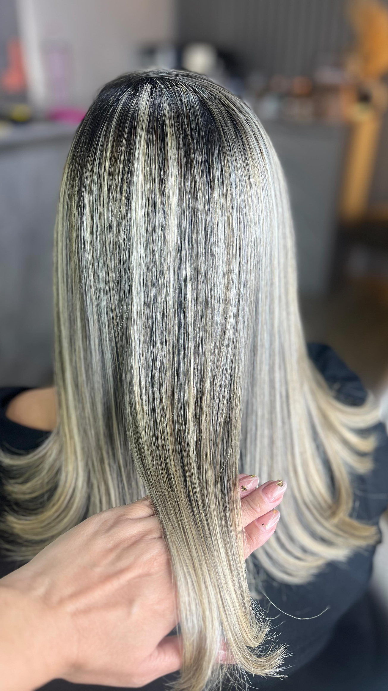 Loiro liso com mechas finas seguradas pela mão